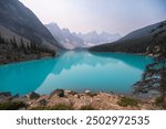 Lake Moraine Turquoise Water Mirror Surface with Canadian Rocky Mountains Behind, Summer Day Haze, Banff 

National Park, Alberta, Canada