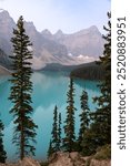 Lake Moraine Turquoise Water Mirror Surface with Canadian Rocky Mountains Behind, Summer Day Haze, Banff 

National Park, Alberta, Canada