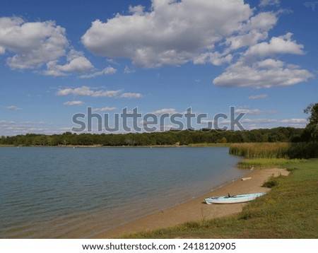 Lake Murray with a boat on the shore and blue sky with white clouds, Oklahoma.