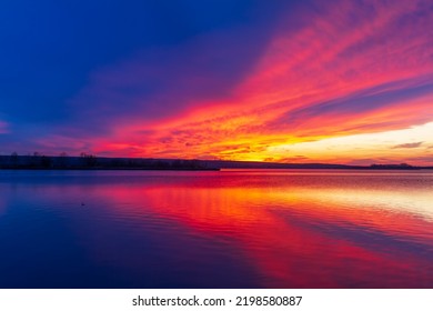 Lake Musov in Palava region in Czech Republic Europe. A dramatic sunset sky is reflected on the surface of the lake.