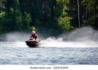 Lake Nokomis, Tomahawk, Wisconsin, USA, August, 20, 2022 - Girl On A Jet Ski Flying Across The Lake, Horizontal