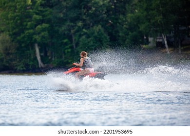 Lake Nokomis, Tomahawk, Wisconsin, USA, August, 20, 2022 - Girl On A Jet Ski Flying Across The Lake, Horizontal