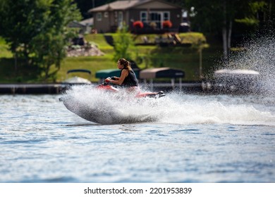 Lake Nokomis, Tomahawk, Wisconsin, USA, August, 20, 2022 - Girl On A Jet Ski Flying Across The Lake, Horizontal