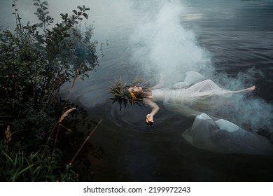 A lake nymph in a white dress and a wreath of flowers floats on the surface of the water. A young woman in a folk image, a mystical story