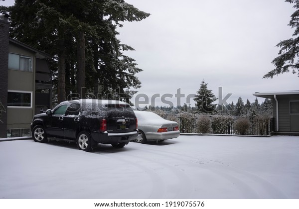 Lake Oswego, OR, USA -\
Feb 13, 2021: A neighborhood parking lot in Lake Oswego, Oregon, on\
a snowy day.