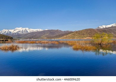 A Lake Reflects The Wasatch Mountain Range Of Utah.