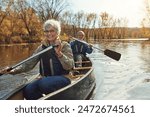 Lake, rowing and kayak with old couple, nature and retirement with happiness, relax and vacation. Outdoor, river and mature man with senior woman, freedom and trust with holiday and weekend break