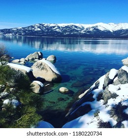 Lake Tahoe In The Winter.  Beautiful Blues And Greens In The Clear Water.  Snowy Mountains Reflecting On The Water.  Bliss