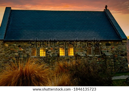 Lake Tekapo historic stone walled  chapel with stunning sunset sunlight coming through the leadlight windows