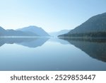 Lake Teletskoye, Altai. Early morning, fog, reflection, sunrise. Gentle beautiful landscapes. Journey to the Altai Nature Reserve, Russia