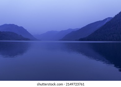 Lake Teletskoye, Altai Republic, Siberia, Russia. Blue clear sky and Mirror of lake. Abstract panoramic landscape, nature environment scene, minimal monochrome background with tonal perspective