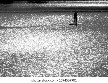 Lake With Thousands Of Glittering Spots And Lonely Surfer In Black And White,