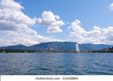 Lake view of Geneva, Switzerland with the Jet d'Eau, Saleve mountains and a blue sky with clouds