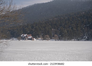 Lake View House, Frozen Lake. House With Forest Behind. Snowy Weather.