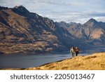 Lake Wakatipu Queenstown fit extreme Caucasian male and female young hiking couple walking mountain travel trail outdoors The Remarkables Otago New Zealand