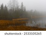 lakescape with old dam in dense fog