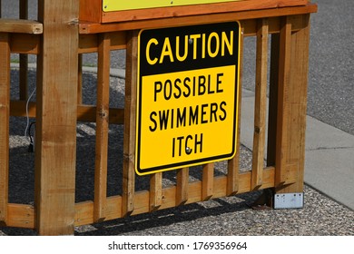 Lakeside Park, Big Lake, MN, USA - July 3,2020. A Warning Sign Alerts Swimmers To The Possibility Of Swimmers Itch. 