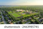 Lakeside urban sprawl lush greenery neighborhood, school district sport complex football field, tennis court, running track, playground in residential area Dallas Fort Worth Metro complex, aerial. USA