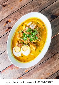 Laksa Curry Noodles - creamy coconut beef laksa soup on white bowl on wood background top view. Copy space - Halal food in Thailand - Shutterstock ID 1507614992