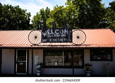 Lamar, Arkansas United States: August 31st, 2022: A Sign On The Roof Of A Community Store On Highway 64 Reads Welcome To Lamar Ark, Home Of 1,415 Fine Folks; Flanked By Wagon Wheels.