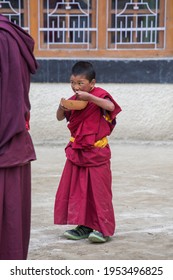Lamayuru Gompa, Ladakh, India - june 14, 2015 : Young buddhist boy with a bowl of food in a monastery Lamayuru, Ladakh, North India
