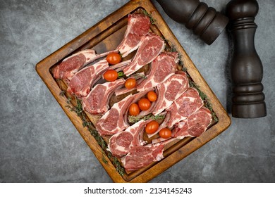 Lamb chops on dark background. Raw lamb chops on wood serving board. Top view