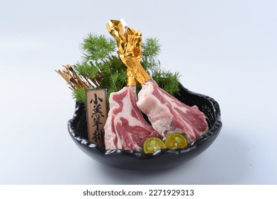 Lamb chops raw meat on bone with salt, pepper and herbs. for Japanese bbq or Korea bbq。Translate：“小羔羊排”meaning is dish name。