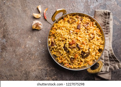 Lamb pilaf in a bowl on stone background, top view with copy space