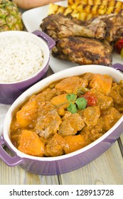 Lamb And Sweet Potato Peanut Stew Served With White Rice. Jerk Chicken And Grilled Pineapple On Background. Caribbean And West African Traditional Dishes.