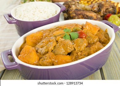 Lamb And Sweet Potato Peanut Stew Served With White Rice. Jerk Chicken And Grilled Pineapple On Background. Caribbean And West African Traditional Dishes.