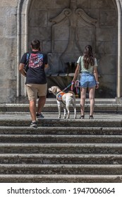 Lamego Portugal - 07 25 2019 : View of young couple climbing the stairs of Lamego Cathedral with labrador guide dog