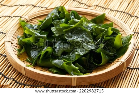Laminaria or Kelp Seaweed in wood plate on wood table Background. fresh Laminaria or kelp Seaweed Background. konbu, alga                                                              