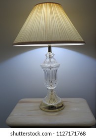 Lamp Antique Style With Crystal Base And Pleated Shade On Marble Bedside Table