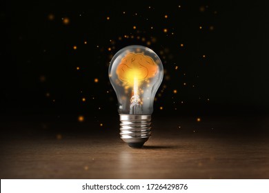 Lamp Bulb With Shining Brain Inside On Wooden Table Against Black Background. Idea Generation