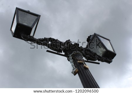 Lamp with Locks on it in Front of Cloudy Sky