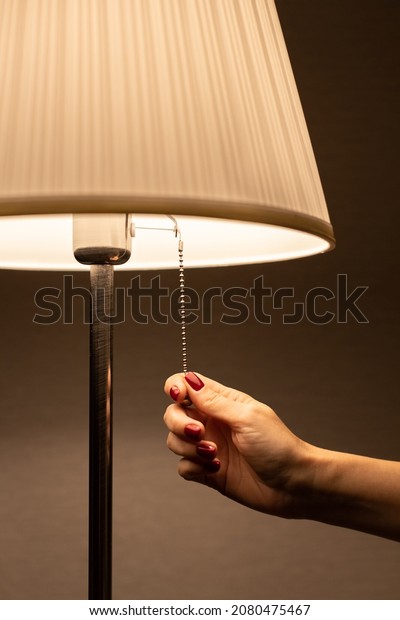 lamp night light by the rope which the hand pulls.\
High quality photo