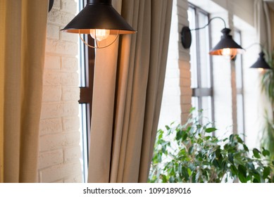 a lamp on the background of a window and a wall with curtains.
