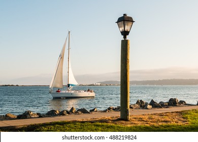 Lamp On Harbor Island With Sail Boat In San Diego Bay.