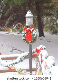 Lamp Post With Christmas Wreath And Covered With Snow