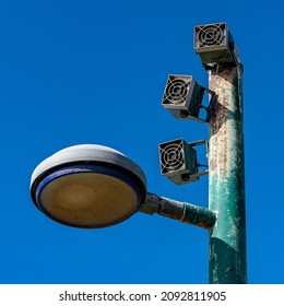 Lamp Post With Loudspeakers Against Blue Sky Close Up