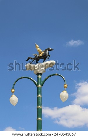 A lamp post in the temple decorated with a small statue of an angel riding a horse. Chonburi Province, eastern region of Thailand.  It is a beautiful Thai art.