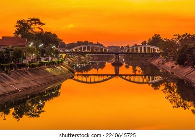 Lampang white bridge across Wang river called "Ratsadaphisek Bridge" in sunset, sunrise and reflection, It is regarded as one of the landmarks of Lampang Province, Thailand. - Shutterstock ID 2240645725