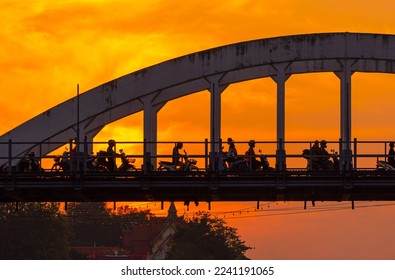 Lampang white bridge across Wang river called "Ratsadaphisek Bridge" in sunset, sunrise and reflection, It is regarded as one of the landmarks of Lampang Province, Thailand. - Shutterstock ID 2241191065