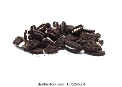 LAMPHUN, THAILAND - NOVEMBER 26, 2019: Oreo Biscuits with cracked and crumbs on white background. Pile of a sandwich cookies filled with sweet cream flavored is the best selling dessert in Thailand. 