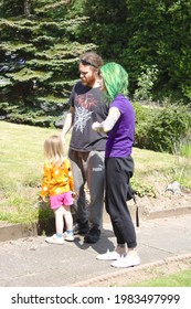 Lancashire, UK, 01-06-2021: Young Happy Family Walking Outdoors. One Parent Has Green Hair 