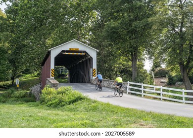 Lancaster County, Pennsylvania- August 9, 2021: Bike Riders go over historic Erb's Mill Covered Bridge. 