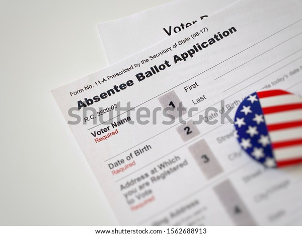 Lancaster, Ohio / USA - November 2019: American\
absentee ballot application form with  an American flag button.\
Presidential election 2020. Early voting voter mail-in ballot\
mail-in voting