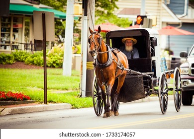 Lancaster, PA / USA - 7/4/2013: Amish man riding a retro carriage on the street