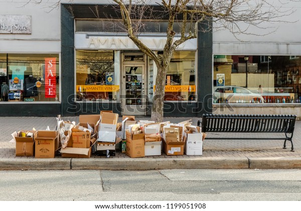 LANCASTER, PENNSYLVANIA - APRIL 4, 2018:\
Several hardboard paper boxes in different shapes and sizes\
abandoned on side of the road. Squeezed cardboard boxes placed\
outdoor waiting to be\
collected.
