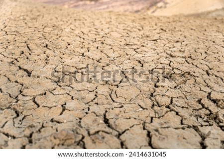 Land destroyed by erosion and global warming - ecological issues concept. shot of cracked soil ground of dried lake or river in mountains.
